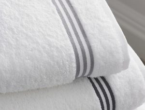 Apartments in Lebanon, IN Close-up of white bath towels with grey stripes on a neatly folded stack resembling a basketball free throw arrangement.