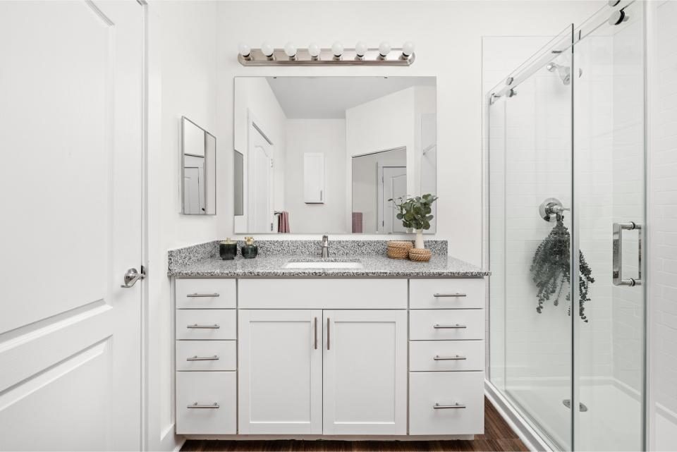 Indiana, Boone County, Lebanon Apartments for rent A modern bathroom with white cabinets, a granite countertop, large mirror, glass shower enclosure, and minimal decor. See all available apartments for rent at Hickory Cottages in Indiana Boone County Lebanon, Hickory Cottages has rental units ranging from 664-1420 sq ft