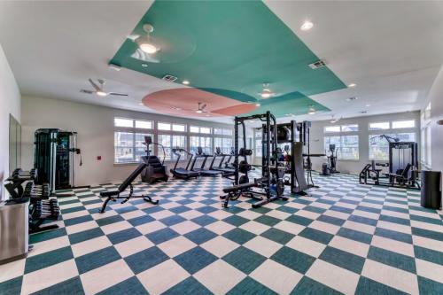 Apartments in Lebanon, IN Modern gym with various exercise equipment, including treadmills, exercise bikes, weights, and strength training machines, on a checkered floor with teal and white ceiling accents.