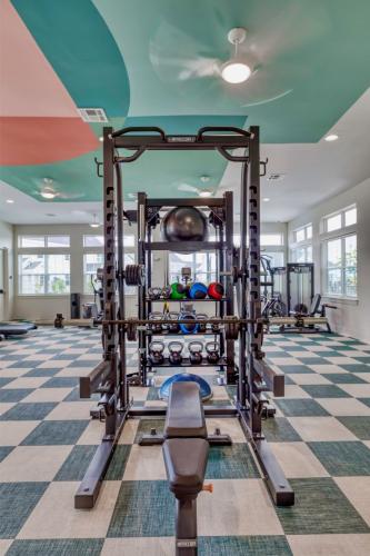 Apartments in Lebanon, IN A modern, well-lit gym with a variety of exercise equipment, including kettlebells, barbells, and resistance bands, arranged neatly around a central weightlifting station.