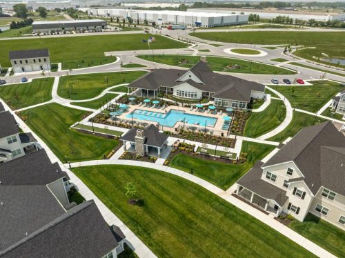 Indiana, Boone County, Lebanon Apartments for rent Aerial view of a residential complex featuring a central outdoor swimming pool, surrounding lounge chairs, landscaped lawns, and adjacent buildings. See all available apartments for rent at Hickory Cottages in Indiana Boone County Lebanon, Hickory Cottages has rental units ranging from 664-1420 sq ft