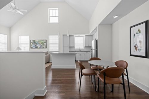 Indiana, Boone County, Lebanon Apartments for rent Modern open-concept kitchen and dining area with white walls, wooden flooring, round dining table with four brown chairs, and natural light from multiple windows. See all available apartments for rent at Hickory Cottages in Indiana Boone County Lebanon, Hickory Cottages has rental units ranging from 664-1420 sq ft