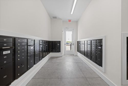 Indiana, Boone County, Lebanon Apartments for rent A hallway lined with black mailboxes on both sides, leading to a glass door with an exit sign above it. See all available apartments for rent at Hickory Cottages in Indiana Boone County Lebanon, Hickory Cottages has rental units ranging from 664-1420 sq ft