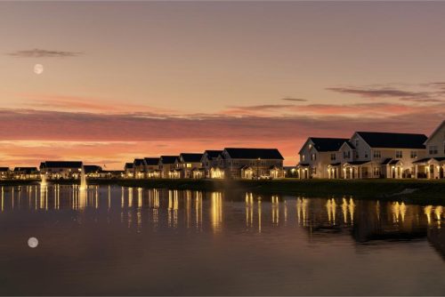 Indiana, Boone County, Lebanon Apartments for rent Row of modern houses reflected in a calm lake at dusk, with warm interior lights and a colorful sky featuring a visible moon. See all available apartments for rent at Hickory Cottages in Indiana Boone County Lebanon, Hickory Cottages has rental units ranging from 664-1420 sq ft