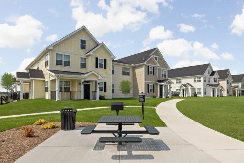 Indiana, Boone County, Lebanon Apartments for rent A picnic table and trash can are situated on a sidewalk in front of modern, two-story suburban houses with well-kept lawns under a partly cloudy sky. See all available apartments for rent at Hickory Cottages in Indiana Boone County Lebanon, Hickory Cottages has rental units ranging from 664-1420 sq ft