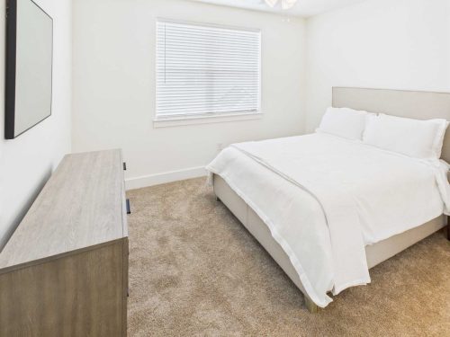 Indiana, Boone County, Lebanon Apartments for rent A tidy bedroom with a beige carpet, a bed with white bedding, a wooden dresser, and a window with closed blinds. See all available apartments for rent at Hickory Cottages in Indiana Boone County Lebanon, Hickory Cottages has rental units ranging from 664-1420 sq ft