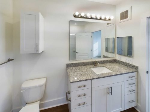 Indiana, Boone County, Lebanon Apartments for rent Modern bathroom with white cabinets, granite countertop, wall-mounted mirrors, overhead light fixture, toilet, and white walls. See all available apartments for rent at Hickory Cottages in Indiana Boone County Lebanon, Hickory Cottages has rental units ranging from 664-1420 sq ft