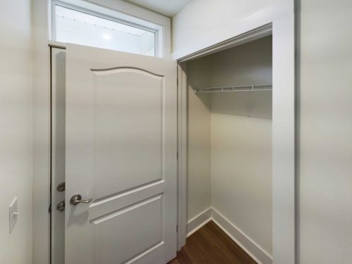 Indiana, Boone County, Lebanon Apartments for rent Empty closet with an open white door, a wire shelf, wood flooring, and a transom window above the door. See all available apartments for rent at Hickory Cottages in Indiana Boone County Lebanon, Hickory Cottages has rental units ranging from 664-1420 sq ft
