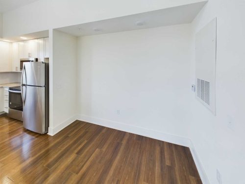 Indiana, Boone County, Lebanon Apartments for rent A small empty room with white walls, wood flooring, and a partial view of a stainless steel refrigerator and kitchen cabinets on the left. See all available apartments for rent at Hickory Cottages in Indiana Boone County Lebanon, Hickory Cottages has rental units ranging from 664-1420 sq ft