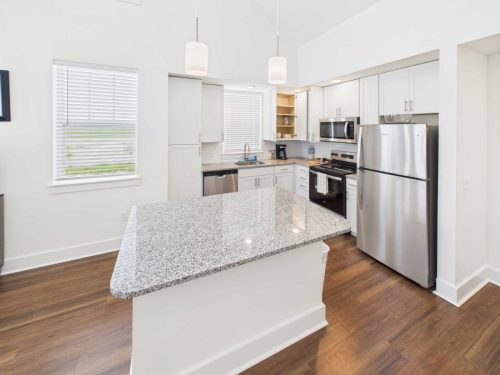 Indiana, Boone County, Lebanon Apartments for rent Modern kitchen with white cabinets, stainless steel appliances, granite island countertop, wood flooring, and pendant lights. See all available apartments for rent at Hickory Cottages in Indiana Boone County Lebanon, Hickory Cottages has rental units ranging from 664-1420 sq ft