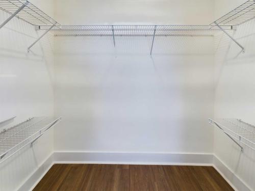 Apartments in Lebanon, IN Empty walk-in closet with white walls, wire shelving on three sides, and brown hardwood flooring.
