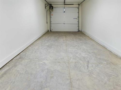 Apartments in Lebanon, IN Empty single-car garage with a concrete floor, white walls, and a closed overhead door.