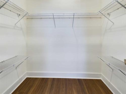 Apartments in Lebanon, IN Empty walk-in closet with white wire shelving units on three walls and a wooden floor.