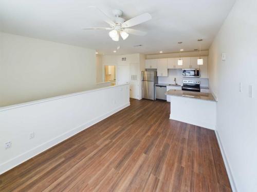 Apartments in Lebanon, IN Discover apartments for rent in Lebanon, Indiana, featuring a modern kitchen and open-concept living area with white walls and wooden floors. Enjoy stainless steel appliances, a ceiling fan, and abundant natural light.