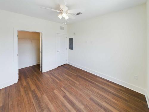 Apartments in Lebanon, IN An empty room with hardwood floors, white walls, a ceiling fan, and an open door leading to a small closet—a perfect blank canvas in one of the charming apartments for rent in Lebanon, Indiana.