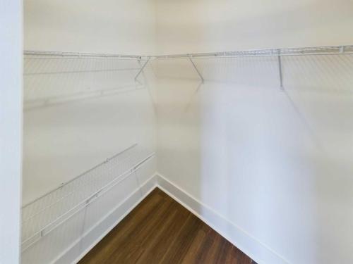 Apartments in Lebanon, IN A white, empty walk-in closet with wire shelving on two walls and a wooden floor is just one of the features offered in our Apartments for Rent in Lebanon, Indiana.