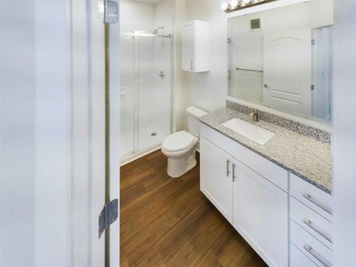 Apartments in Lebanon, IN Discover charming apartments for rent in Lebanon, Indiana. Each offers a pristine white bathroom with a wooden floor, featuring a granite countertop with sink, a toilet, and a glass-enclosed shower.