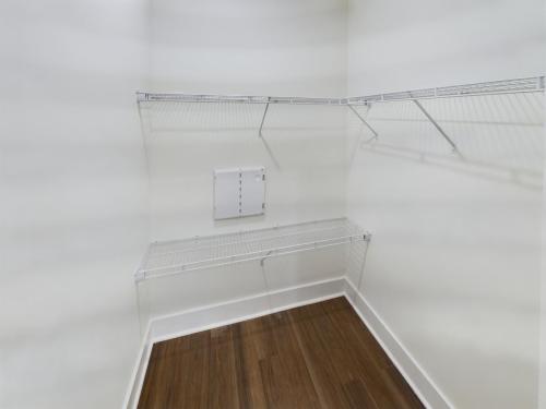 Apartments in Lebanon, IN Empty walk-in closet with white walls, wooden floor, and metal wire shelving on three sides.