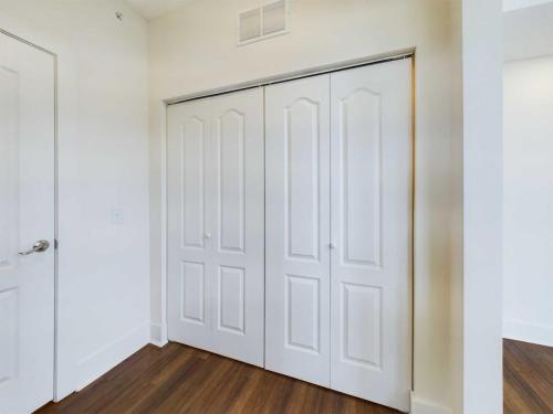 Apartments in Lebanon, IN A white closet with double doors in a room with white walls and wooden flooring.