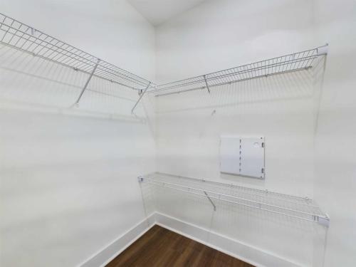 Apartments in Lebanon, IN Empty closet with white walls, wooden floor, and two levels of wire shelving on two walls.