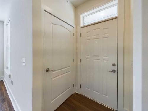 Apartments in Lebanon, IN A white interior door next to a front door with a window above it. Both doors are closed. The floor is wooden.