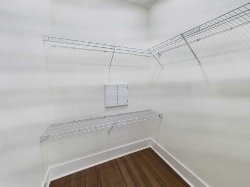 Apartments in Lebanon, IN Empty white closet with wooden floor and metal wire shelves on three walls.