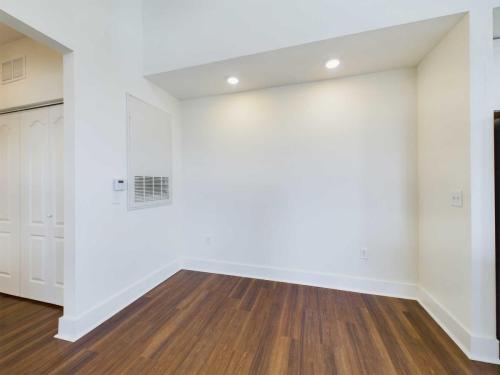 Apartments in Lebanon, IN Empty room with white walls, recessed lighting, wooden floor, and a small air vent on one wall.