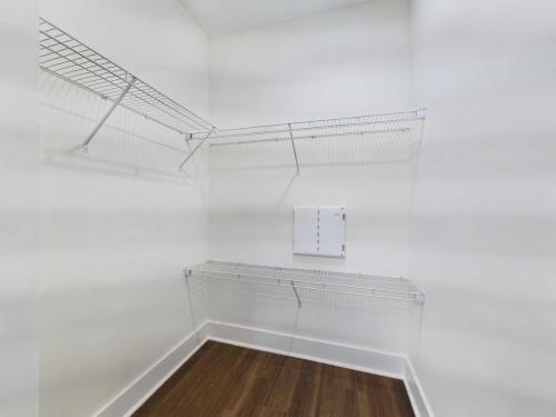 Apartments in Lebanon, IN Empty walk-in closet with white walls, metal wire shelving, and wooden flooring.