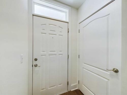 Apartments in Lebanon, IN Closed white front door and adjacent closet door in a well-lit interior space with a wooden floor.