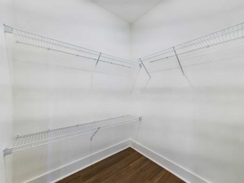 Apartments in Lebanon, IN An empty walk-in closet with white walls, wire shelving units on three sides, and a wood floor.