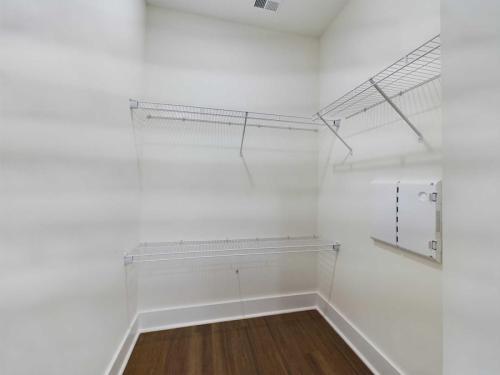 Apartments in Lebanon, IN Empty walk-in closet with wire shelving on the walls and a hardwood floor.