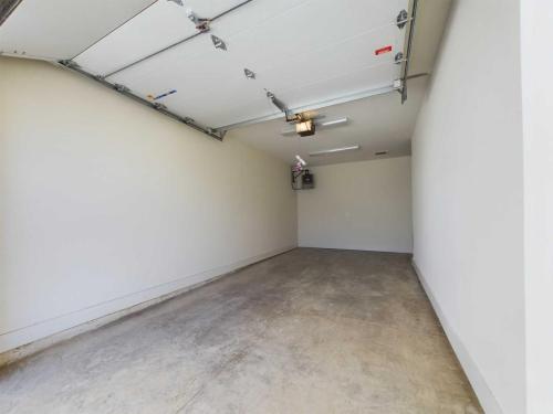 Apartments in Lebanon, IN An empty, clean garage with a concrete floor, white walls, and an open overhead garage door, with a ceiling-mounted motorized opener.