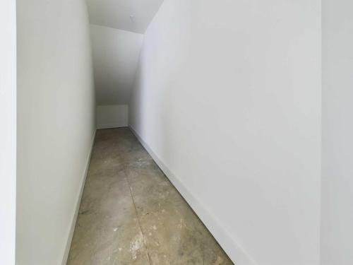 Apartments in Lebanon, IN A narrow, unfinished hallway with white walls and a concrete floor, leading to a small, closed-off area.