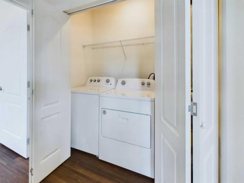 Apartments in Lebanon, IN A laundry area with a white washer and dryer set, located behind white double doors.