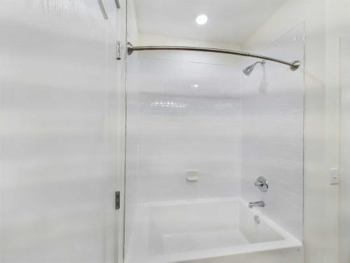 Apartments in Lebanon, IN A white bathtub with a tiled surround, showerhead, faucet, and a curved shower rod.