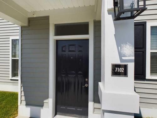 Indiana, Boone County, Lebanon Apartments for rent Front view of a modern house with a black door, gray siding, a large pillar, and address plaque reading 7102. See all available apartments for rent at Hickory Cottages in Indiana Boone County Lebanon, Hickory Cottages has rental units ranging from 664-1420 sq ft