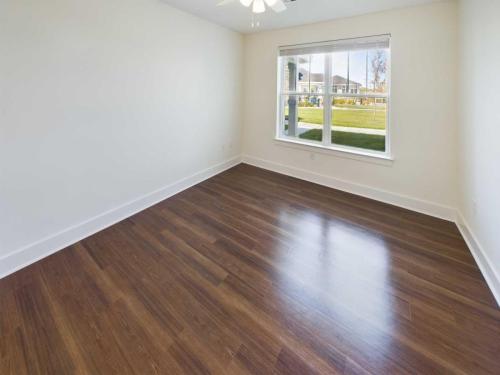 Indiana, Boone County, Lebanon Apartments for rent Empty room with wooden flooring, a large window, and white walls. The window reveals a grassy area outside. See all available apartments for rent at Hickory Cottages in Indiana Boone County Lebanon, Hickory Cottages has rental units ranging from 664-1420 sq ft