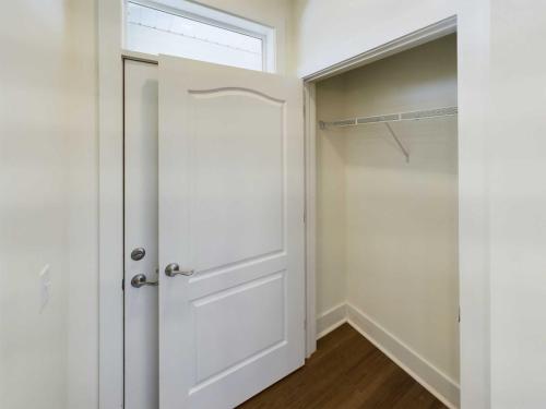 Indiana, Boone County, Lebanon Apartments for rent Open white closet door revealing an empty closet with a wooden floor and metal shelf. See all available apartments for rent at Hickory Cottages in Indiana Boone County Lebanon, Hickory Cottages has rental units ranging from 664-1420 sq ft